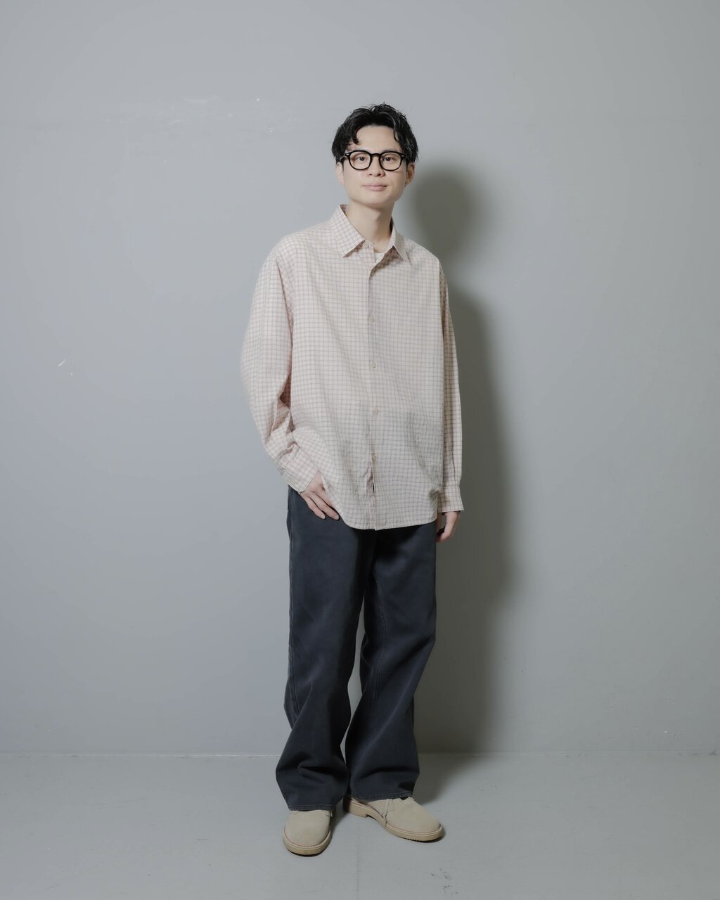 ライトピンクシャツとデニムパンツを着た男性
