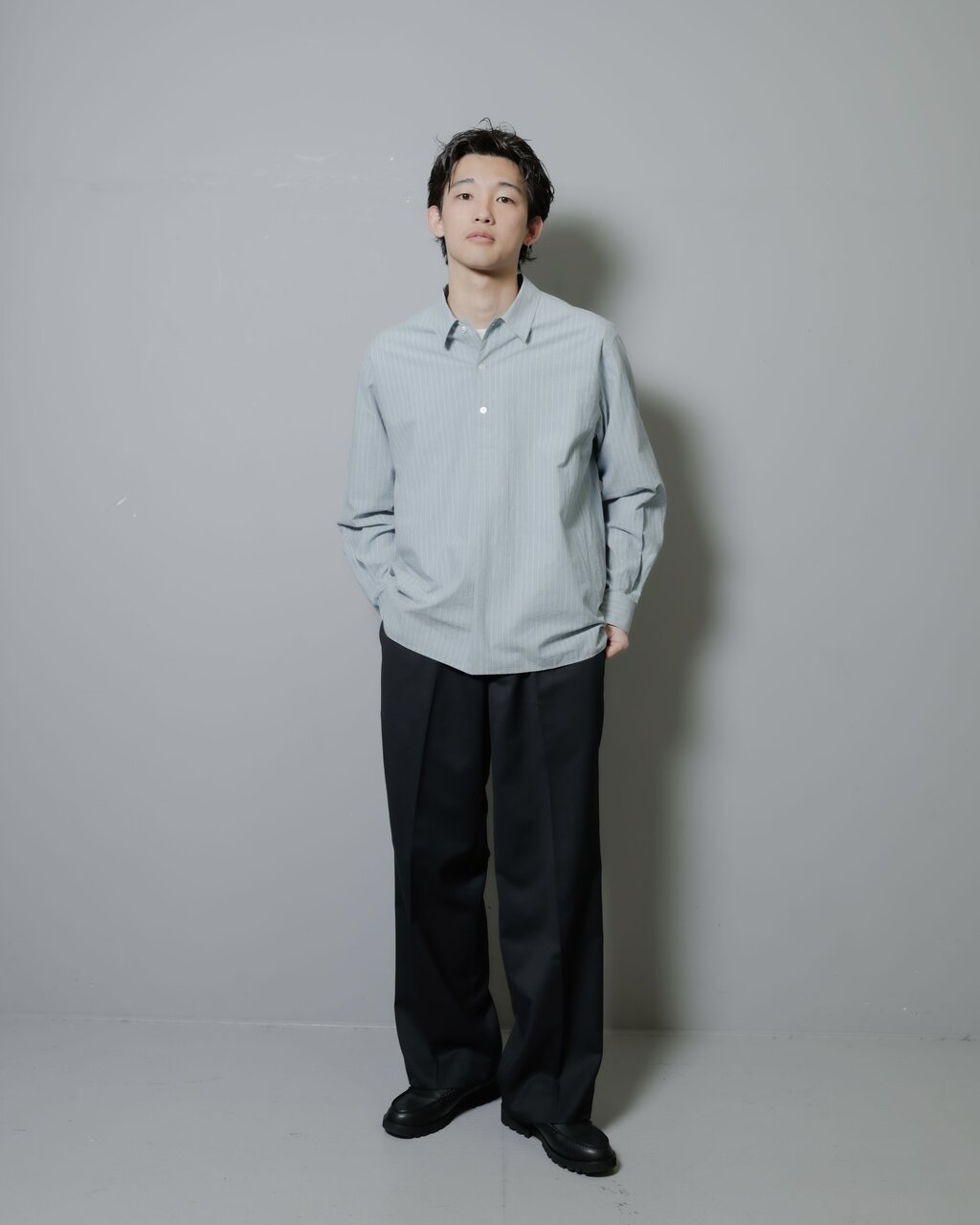 プルオーバーシャツとスラックスを着た男性