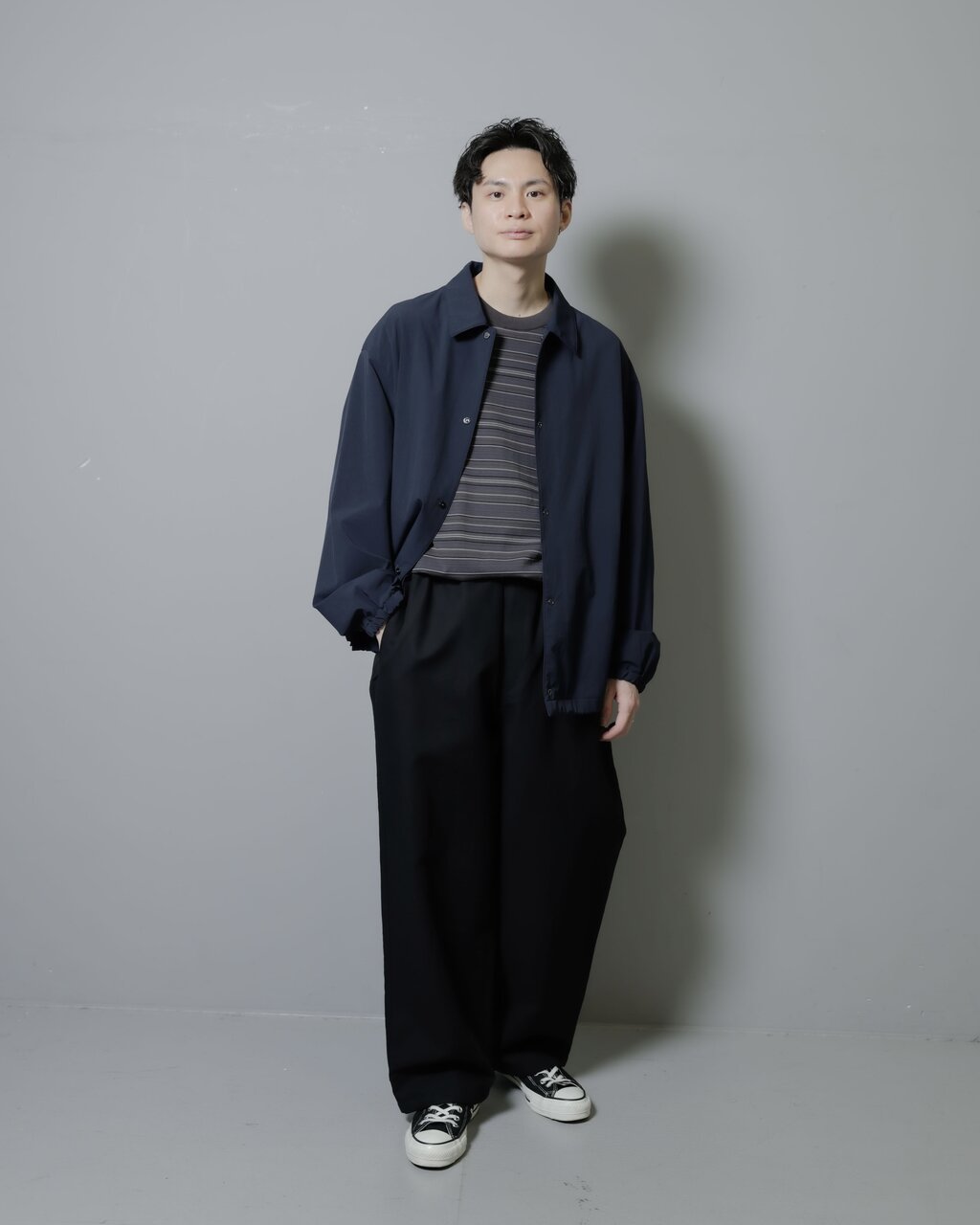 ブルゾンとワイドパンツを着た男性