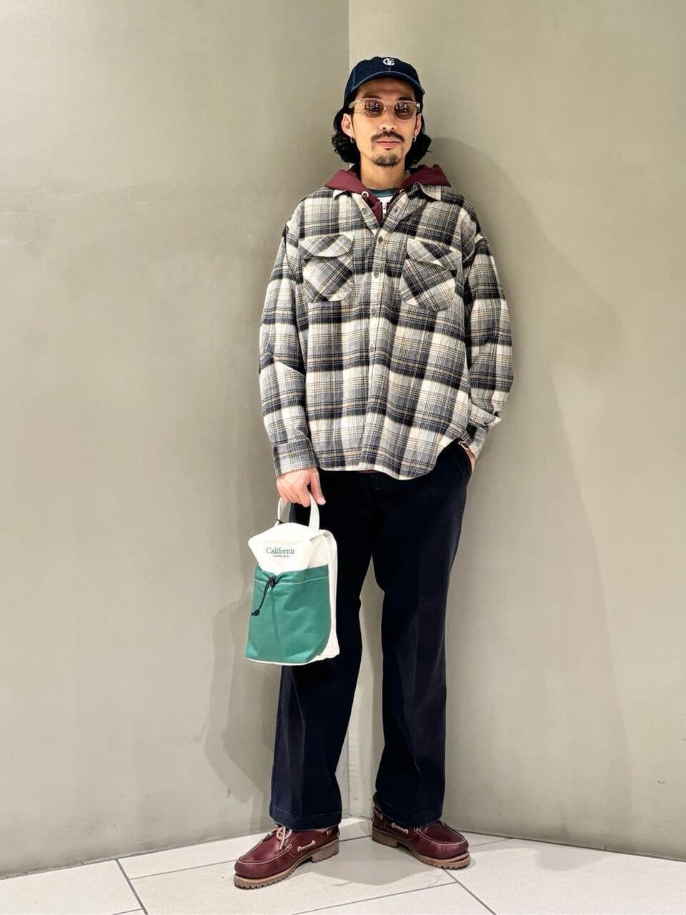 チェックシャツとチノパンを着た男性