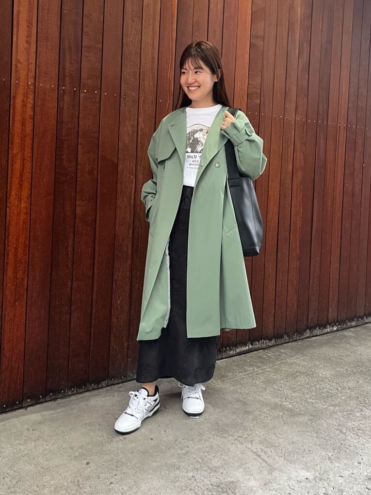オリーブ色のトレンチコートを着た女性