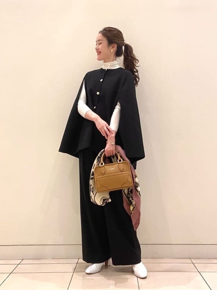 ケープカーディガンを着用している女性