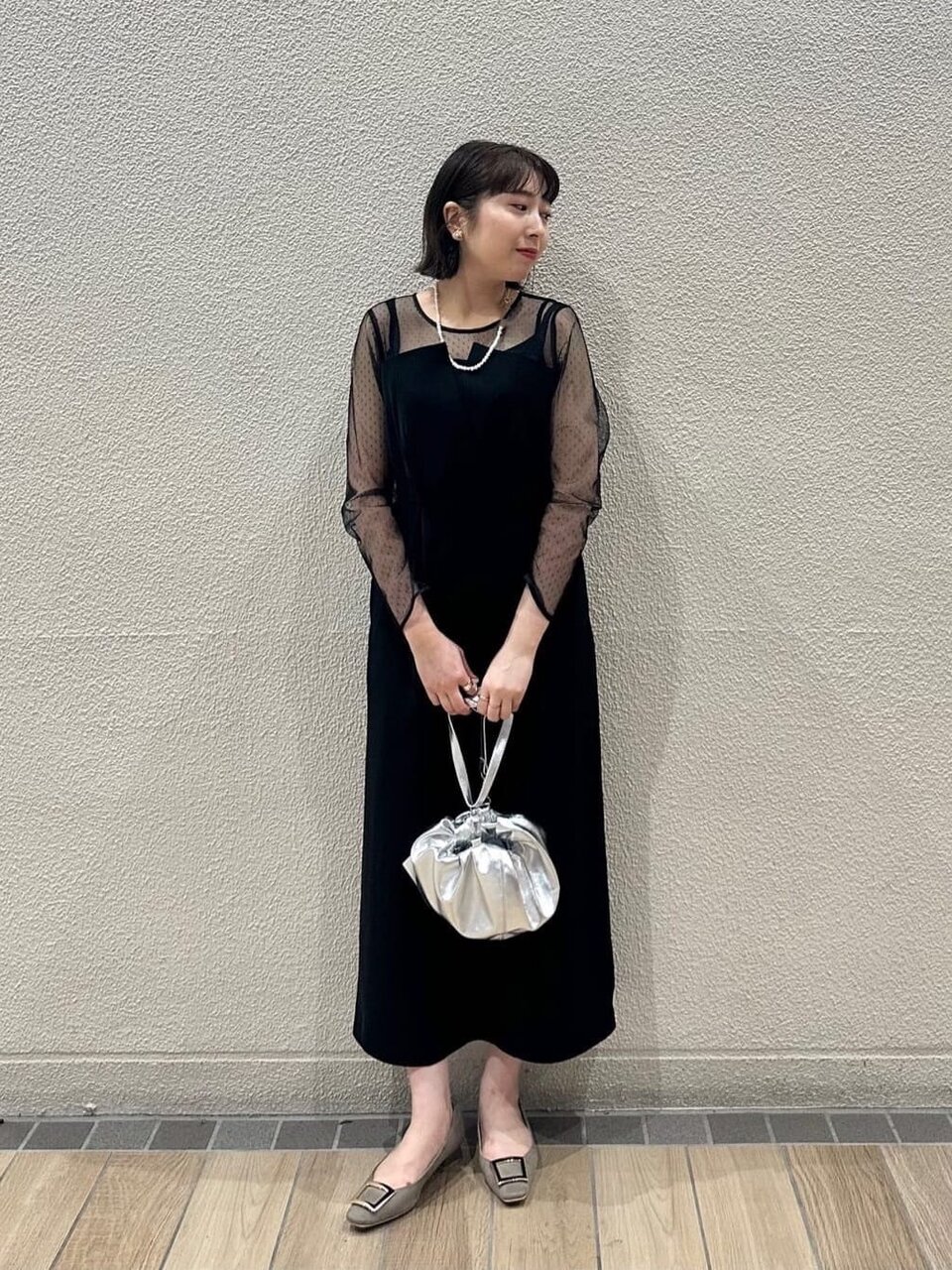 シルバーのバッグを持つ女性