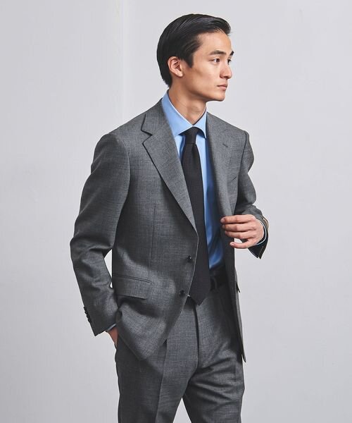 ブルーのシャツとグレーのスーツを着た男性