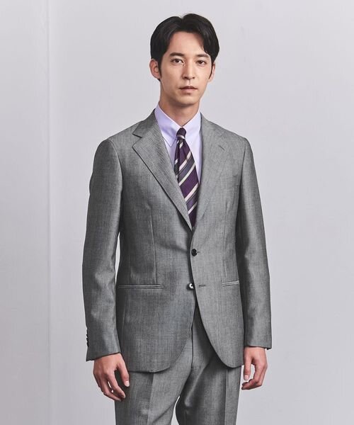 パープルのシャツとグレーのスーツを着た男性