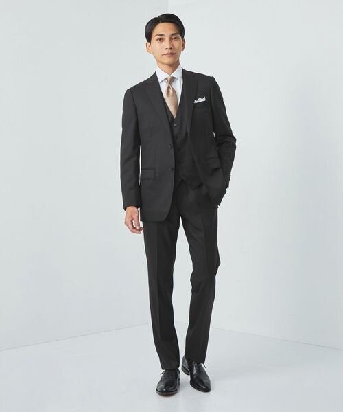 黒のスリーピーススーツを着た男性