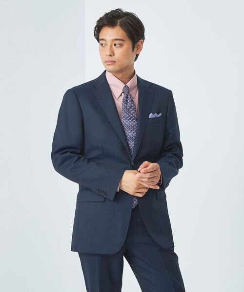 チーフを挿したネイビーのスーツを着た男性