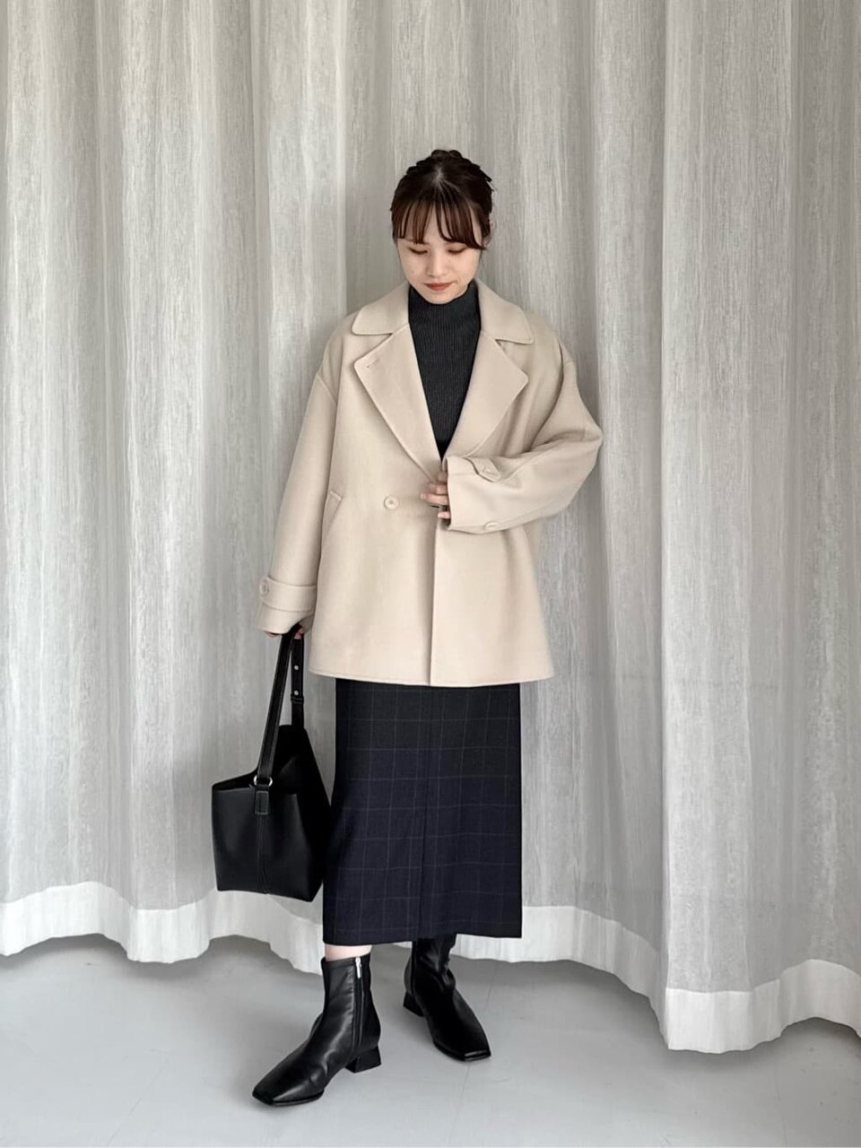 ベージュのコートとスカートを着た女性