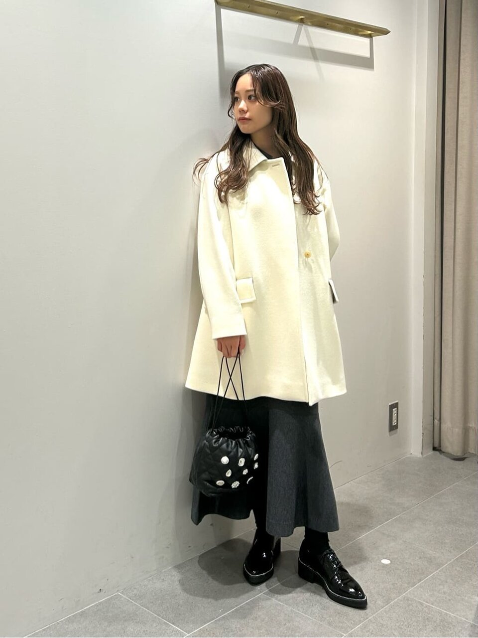 スタンドカラーコートとワンピースを着た女性