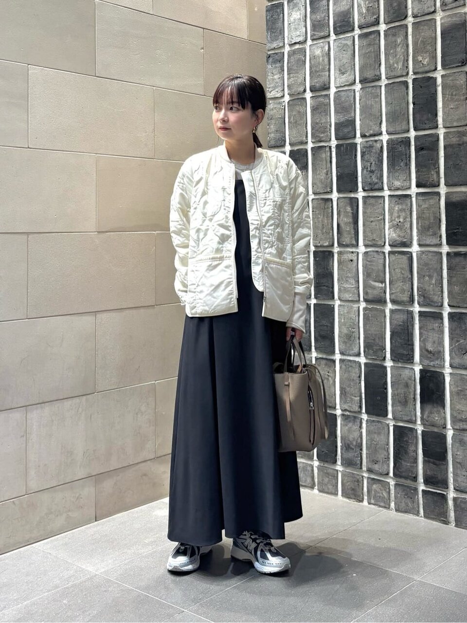 白いブルゾンとワンピースを着た女性
