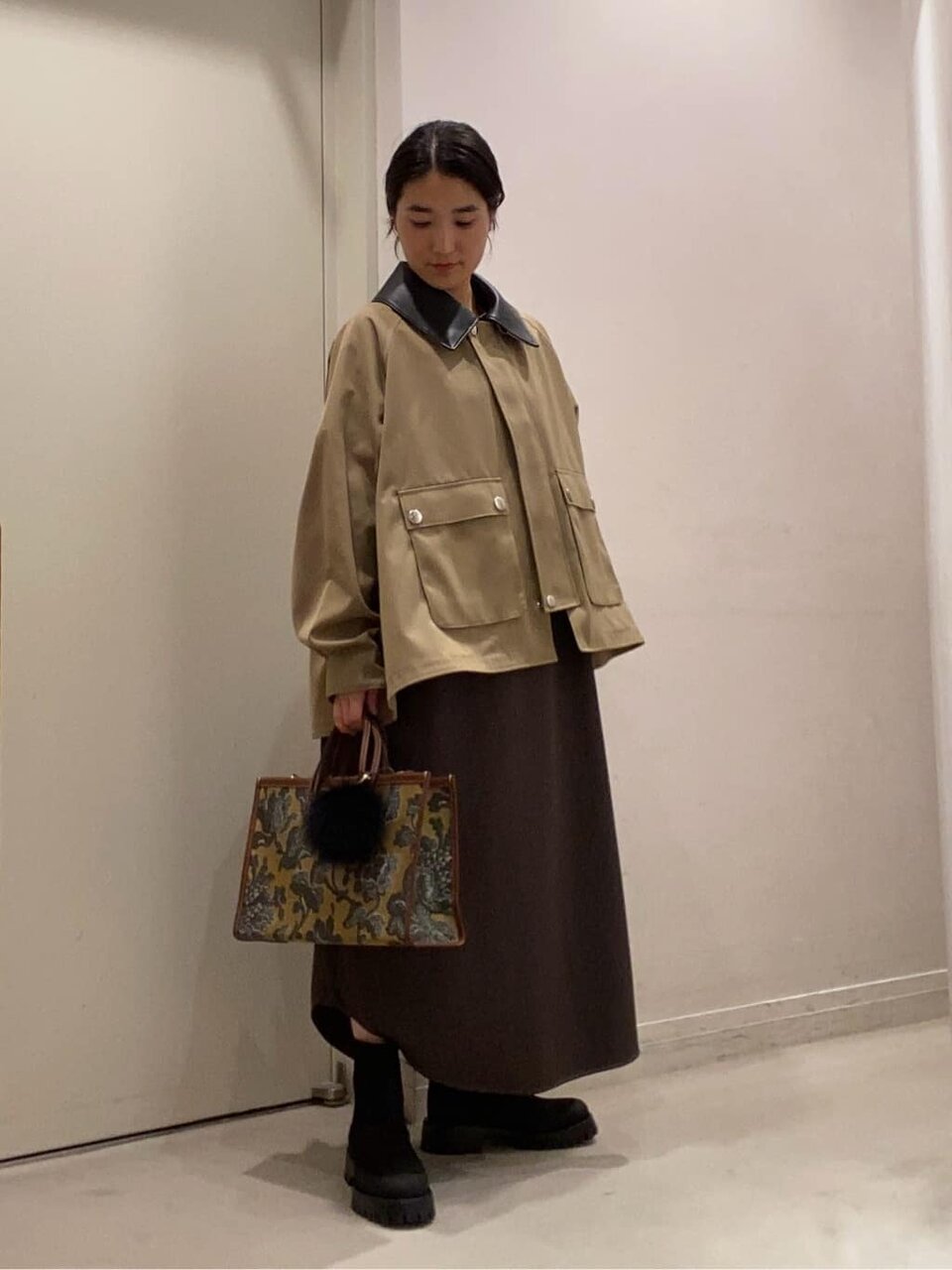 ポンチョブルゾンとワンピースを着た女性