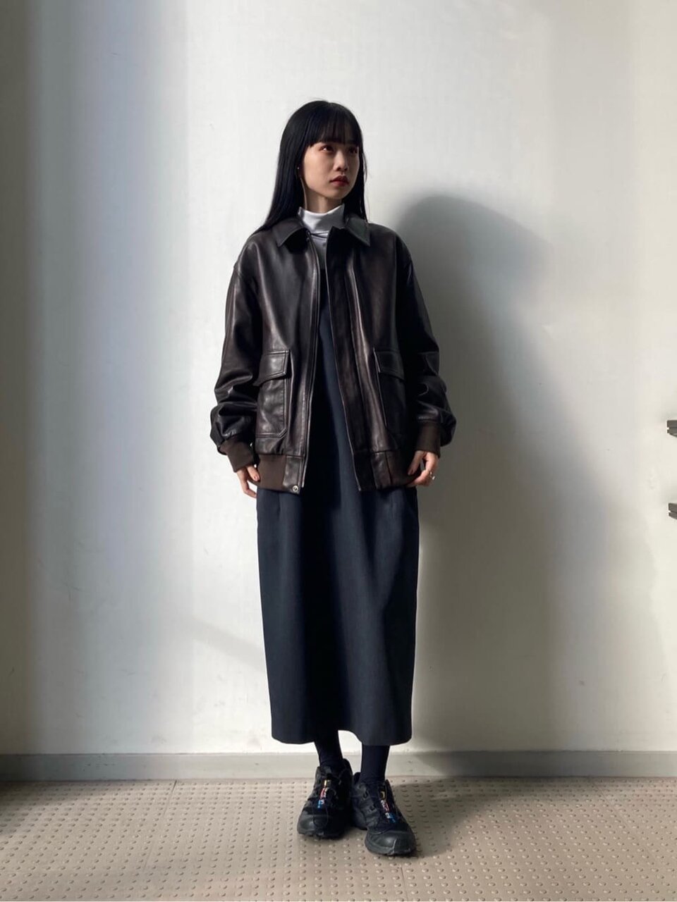 レザーブルゾンとワンピースを着た女性