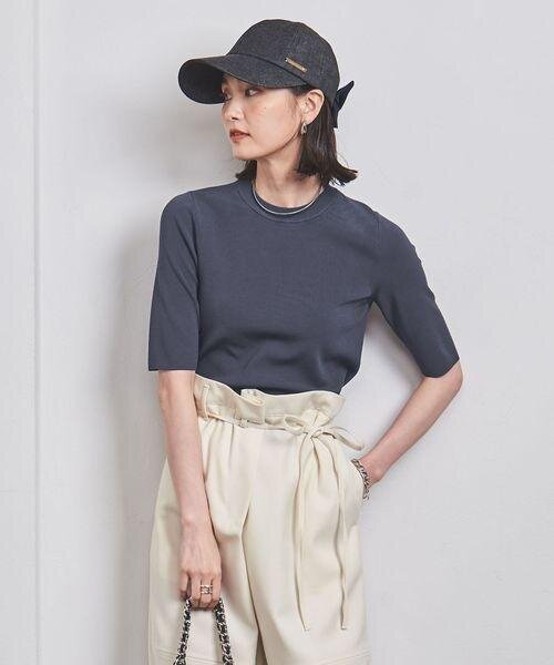 ダークグレーのクールネックニットを着ている女性