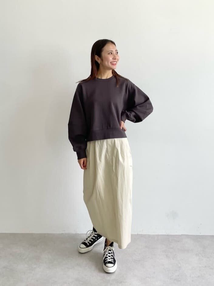 茶色のスウェット×オフホワイトのスカートコーデの女性