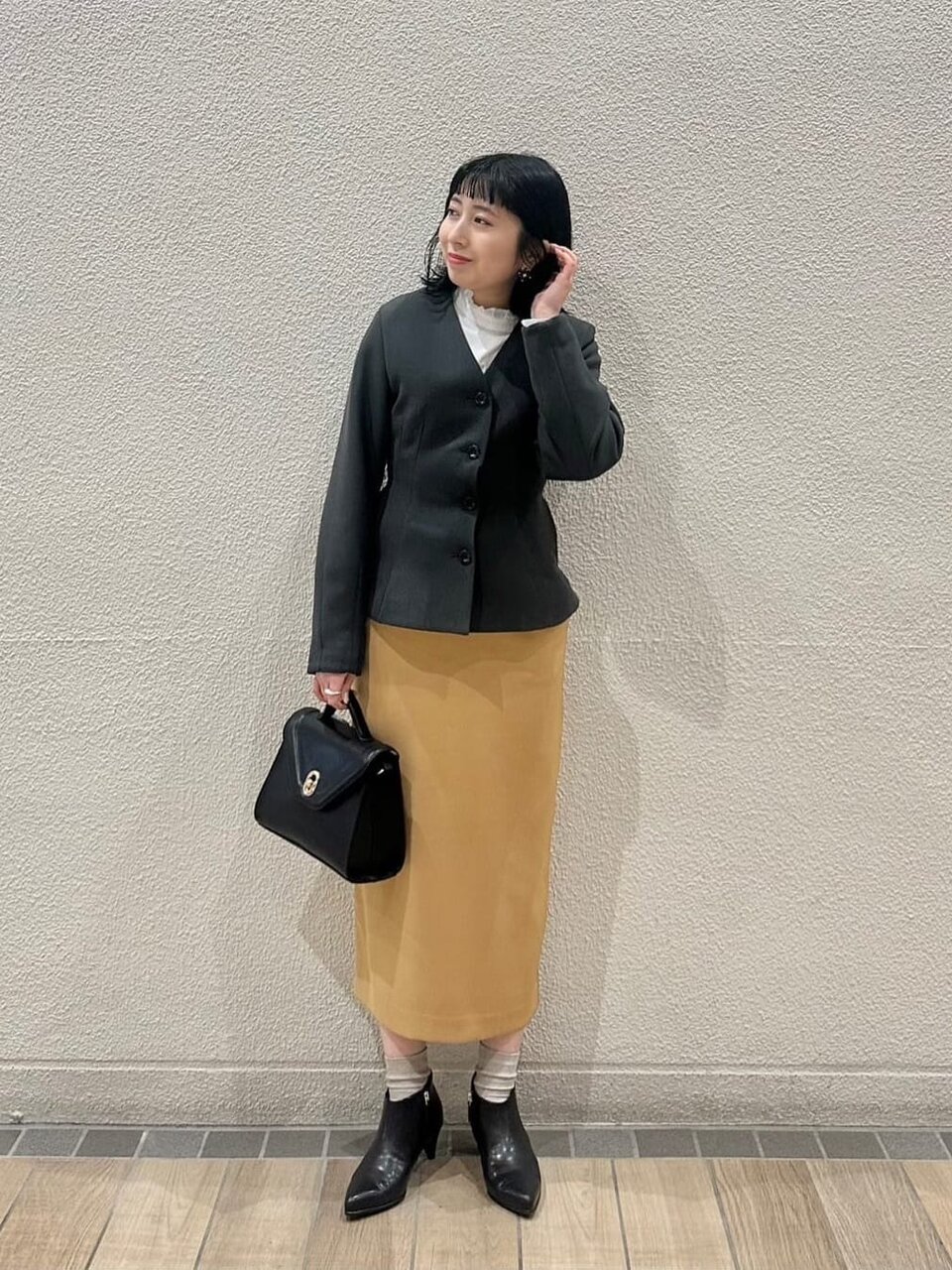 茶色のスカート×ダークグレーのジャケットコーデの女性