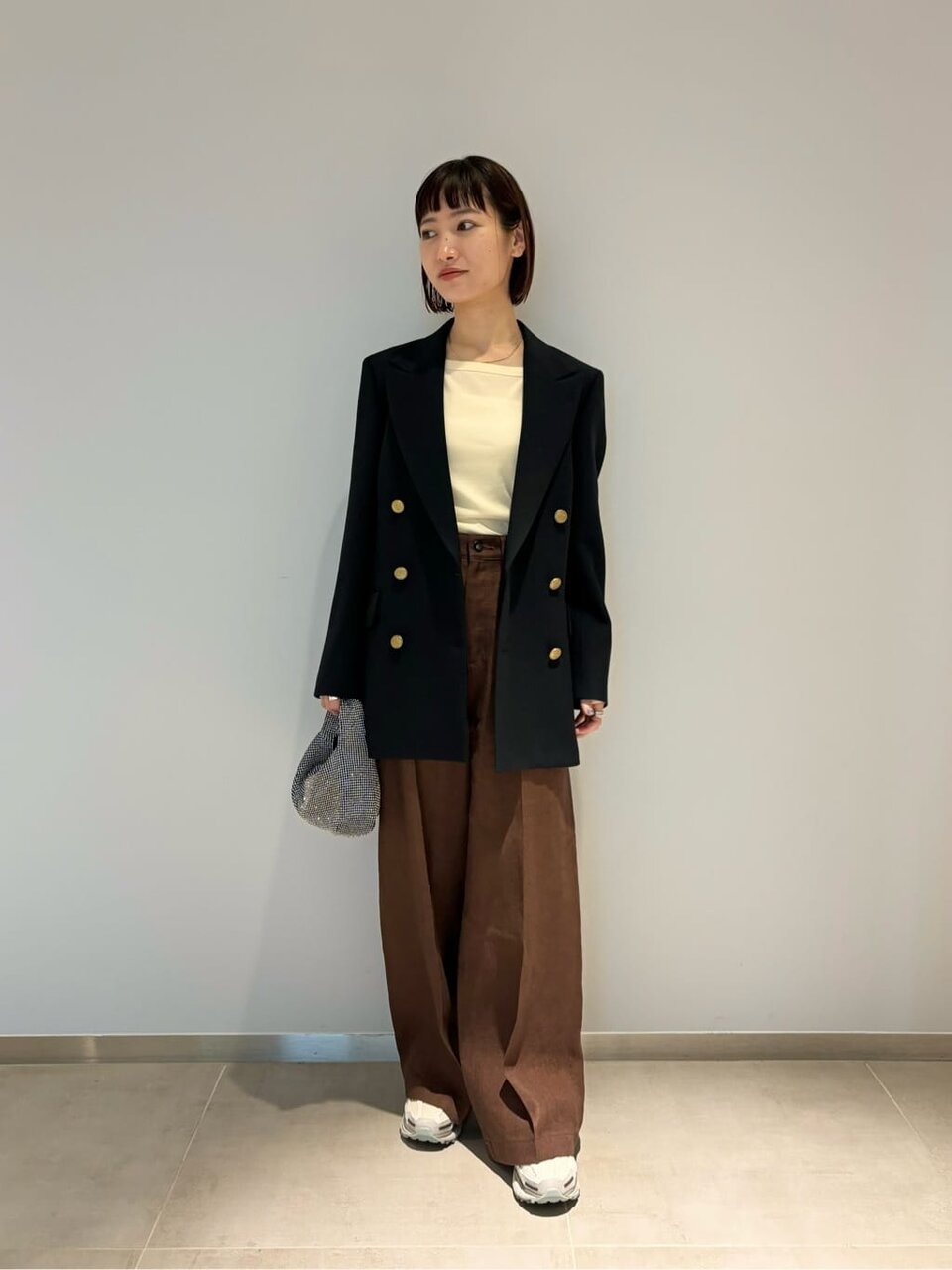 茶色のパンツ×ネイビーのジャケットコーデの女性