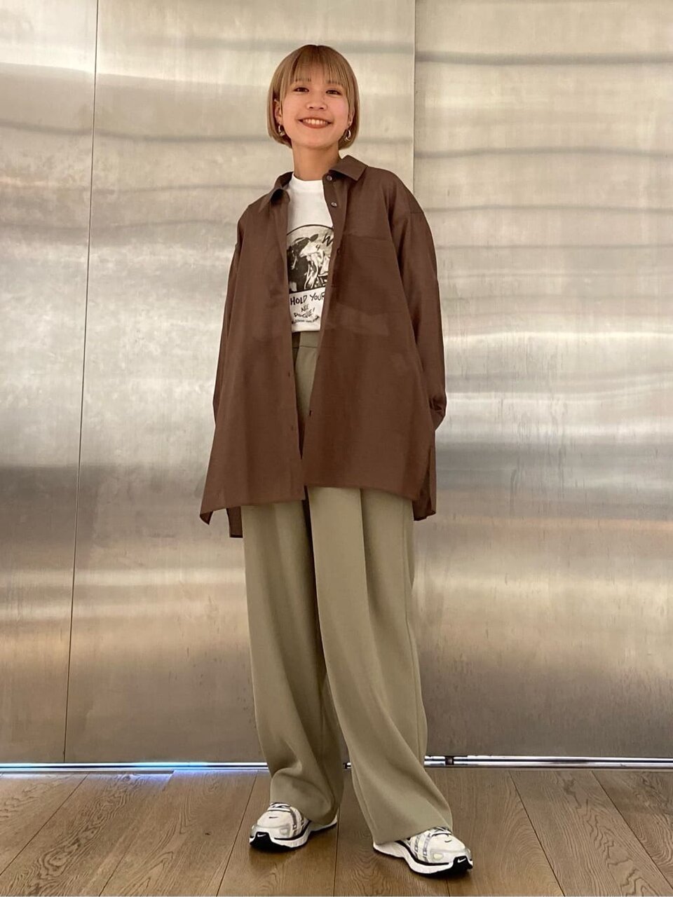 茶色のシャツ×ライムグリーンのパンツコーデの女性