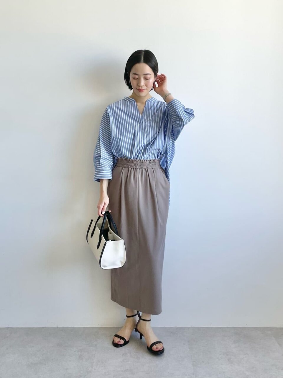 茶色のスカート×ブルー系ストライプ柄シャツコーデの女性