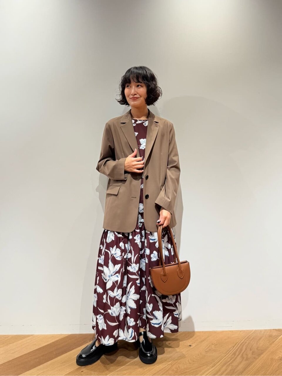 テーラードジャケットと花柄ワンピースの女性