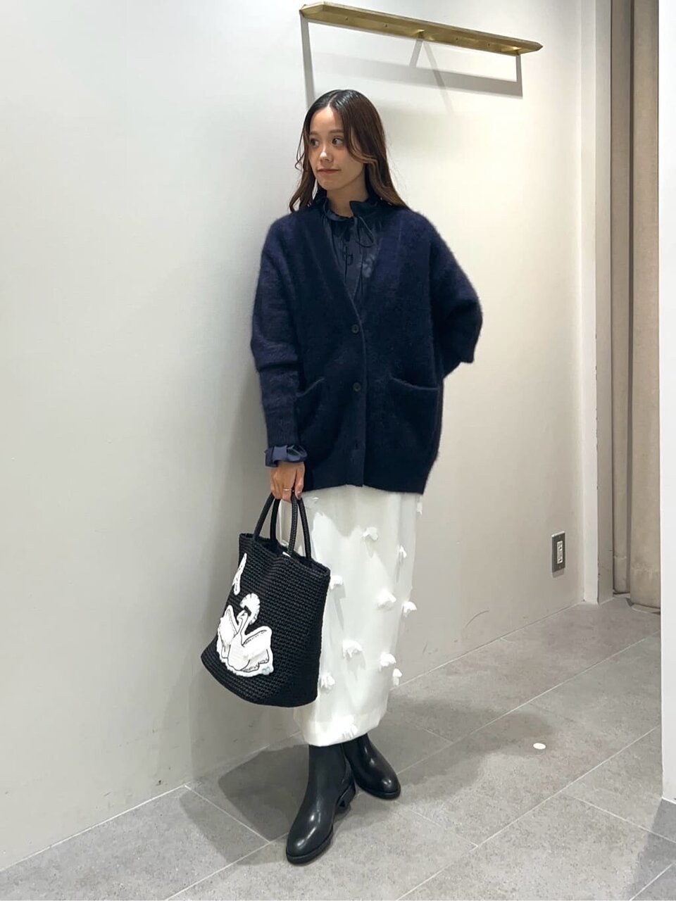 カーディガンにデザインスカートをあわせた女性