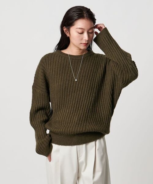オリーブカラーのニットを着た女性