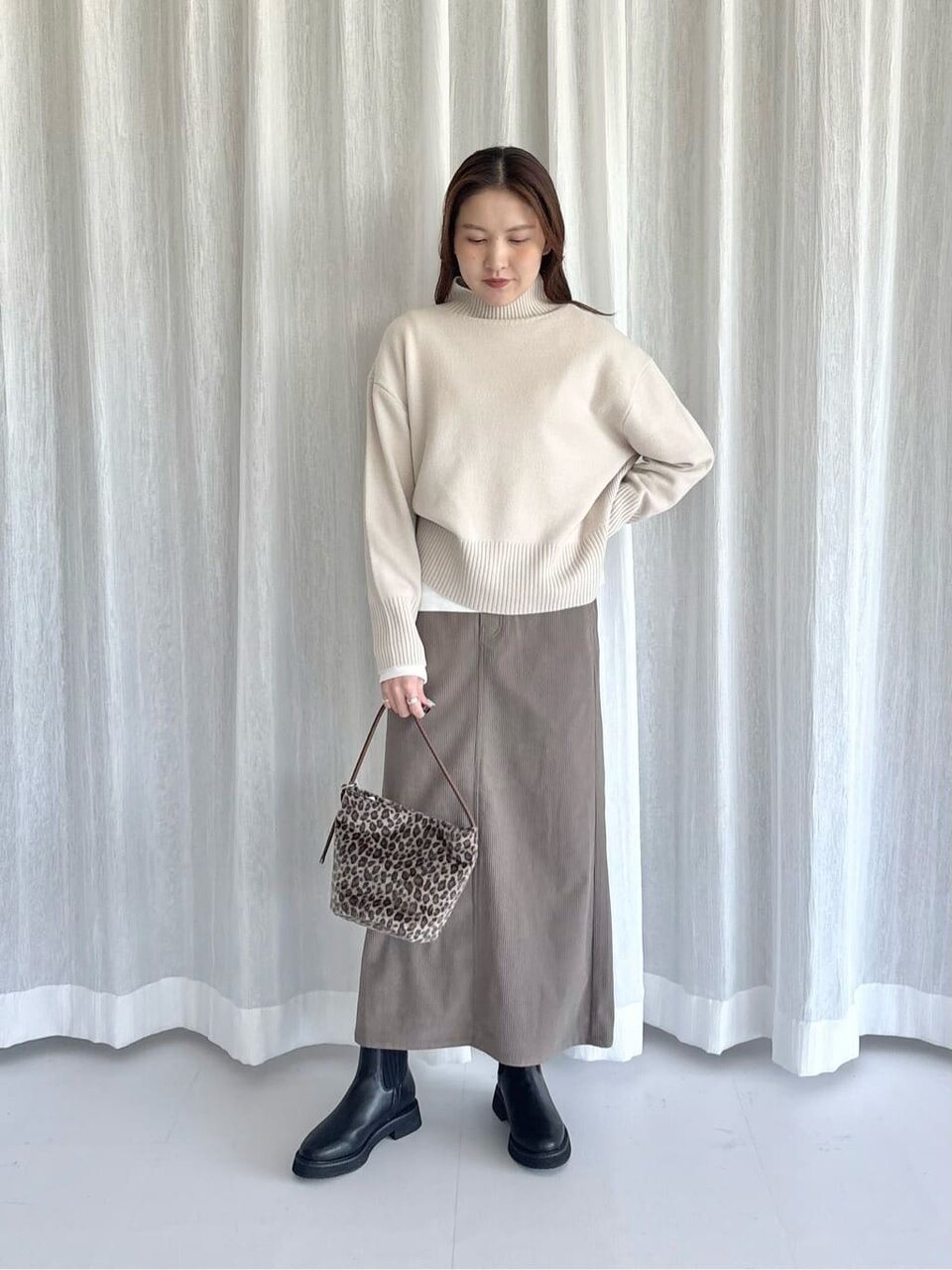 ナチュラルカラーのニットを着た女性