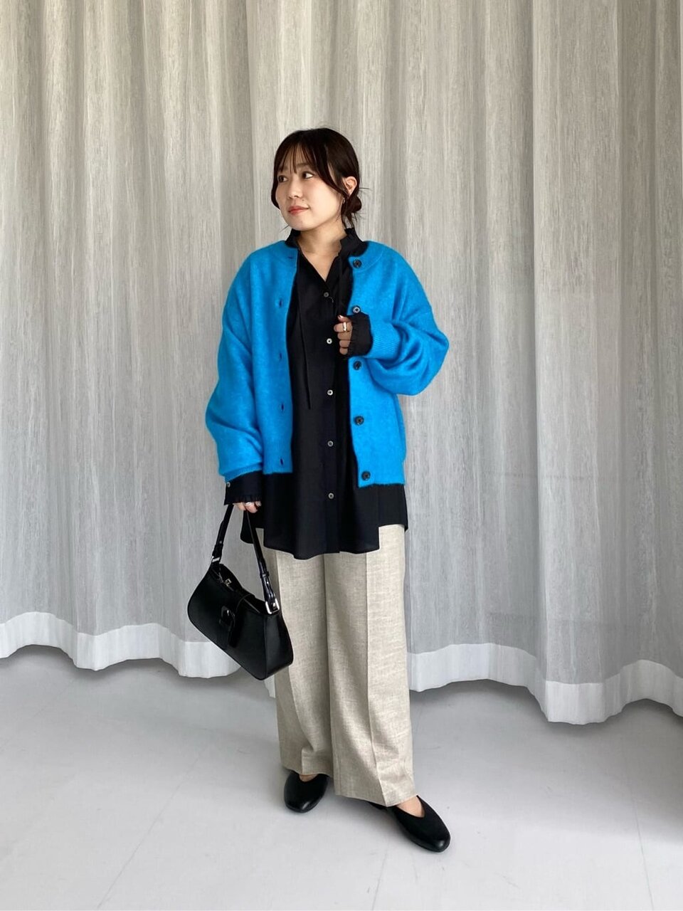 カーディガンとパンツをあわせた女性