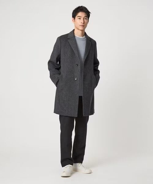 グレー系カラーのチェスターコートを着ている男性