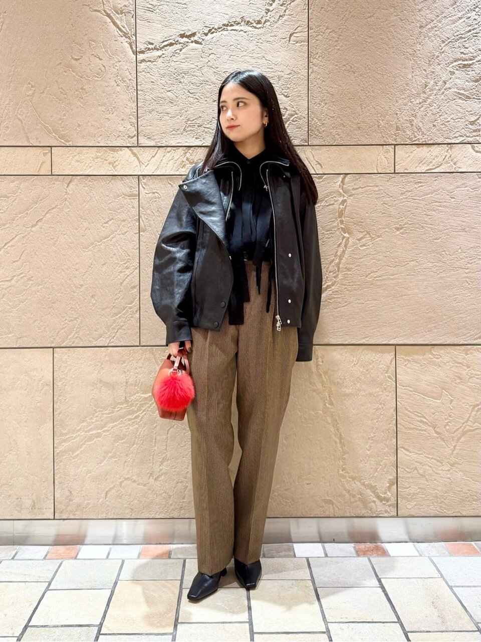 レザージャケットとテーパードパンツをあわせた女性