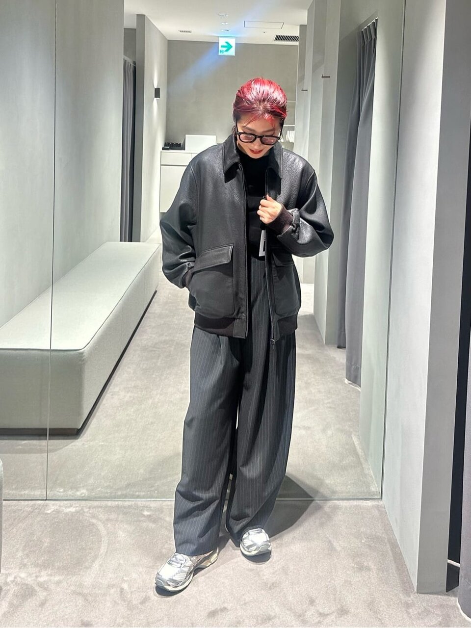 レザージャケットとカーブパンツをあわせた女性