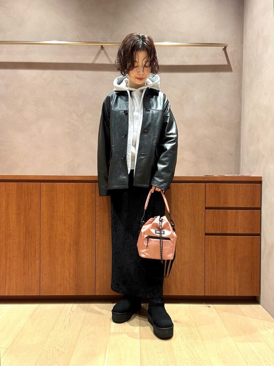 レザージャケットにタイトスカートをあわせた女性