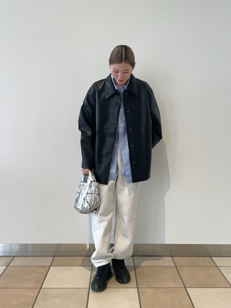 レザージャケットにスウェットパンツをあわせた女性