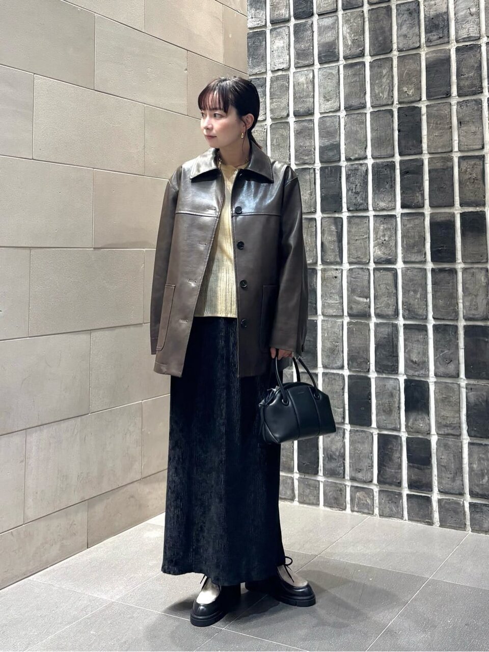 レザージャケットに黒のタイトスカートをあわせた女性