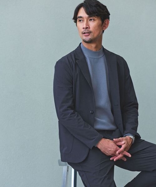 スーツにモックネックニットを着た男性