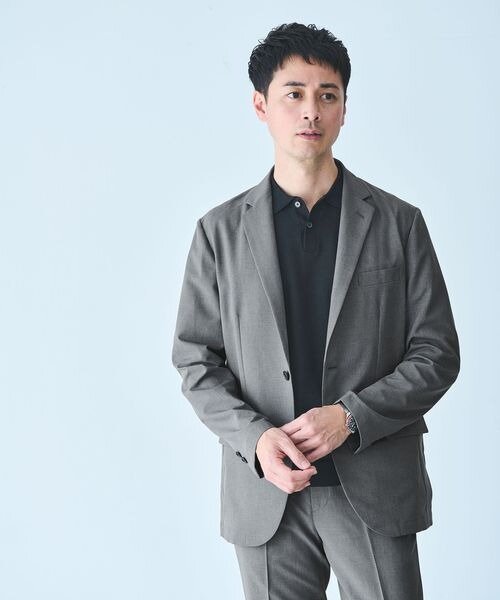 スーツにポロシャツを着た男性