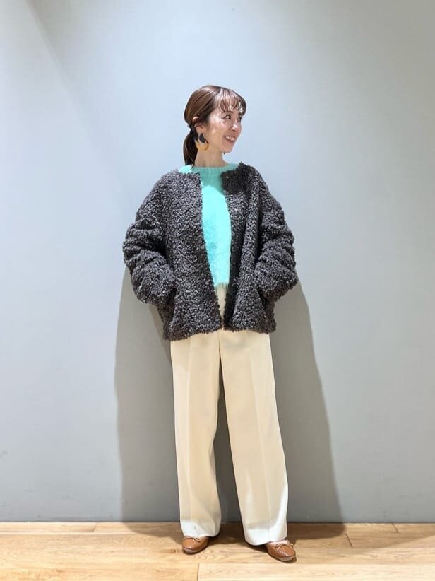 ノーカラーのボアブルゾンを着用した女性