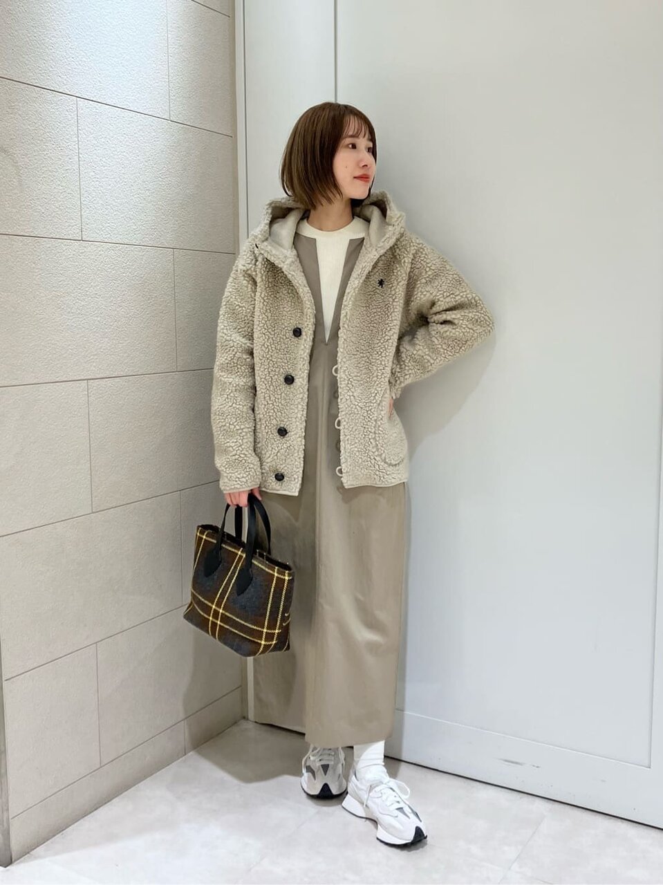 ナチュラルカラーで統一したコーデを着用した女性