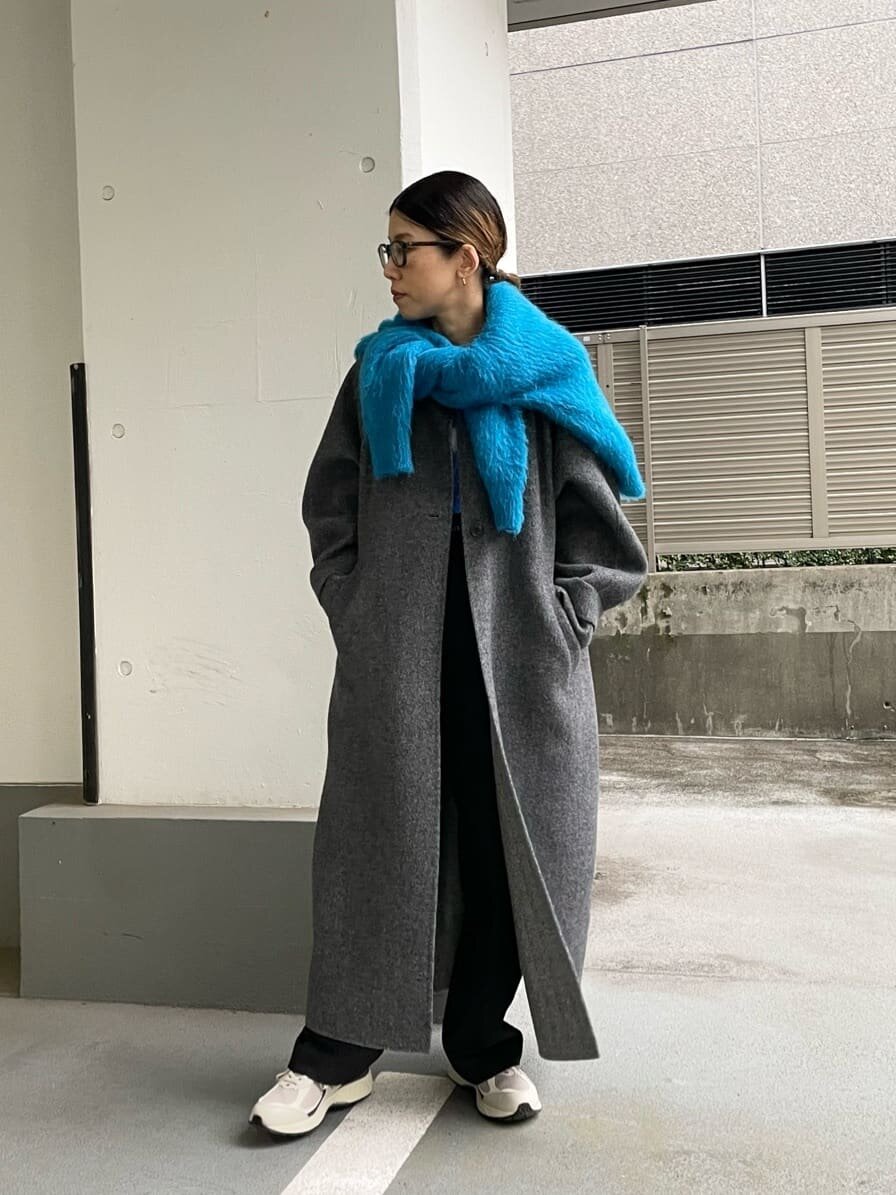 フリンジニットとワイドパンツを着た女性