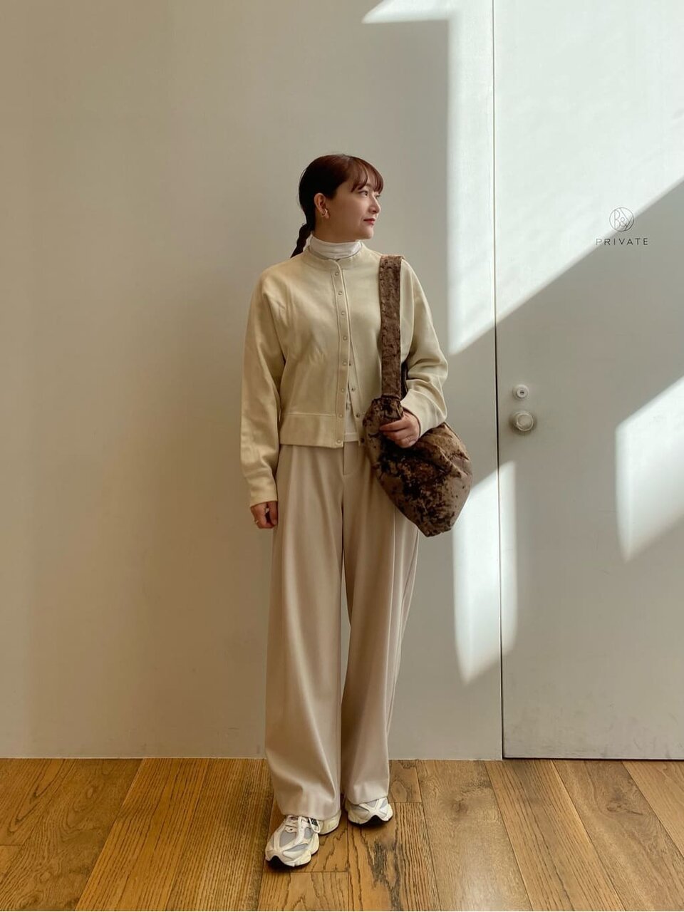 フリンジニットとワイドパンツを着た女性