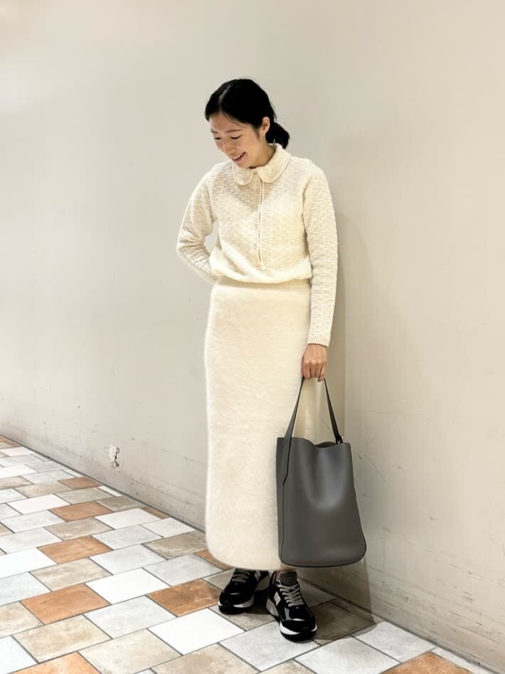ニットとフレアスカートを着た女性