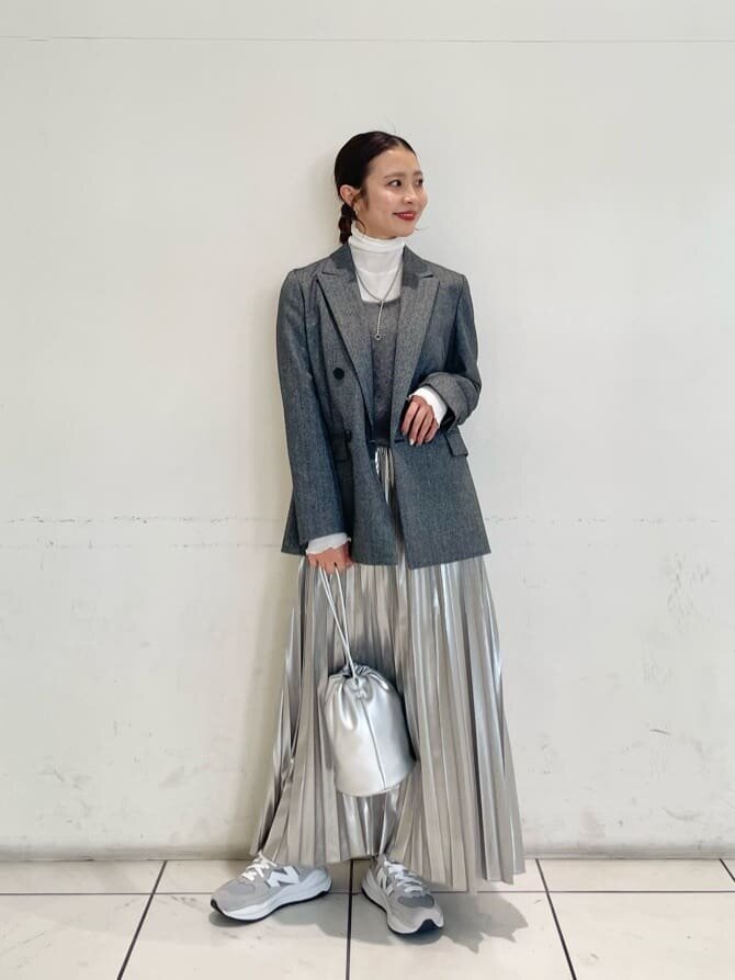 赤いニットとグレーのスカートを着た女性