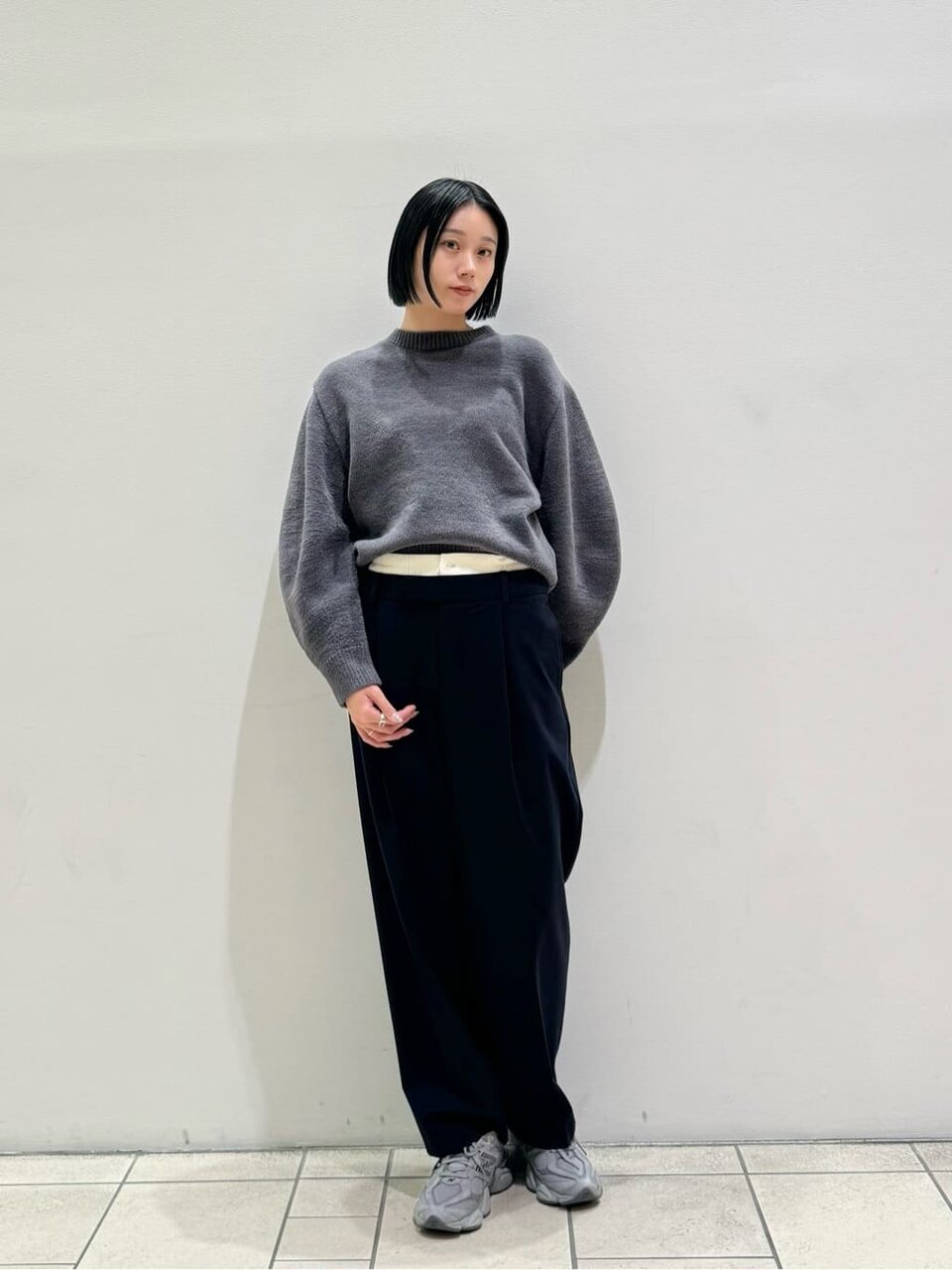 赤いニットとグレーのスカートを着た女性