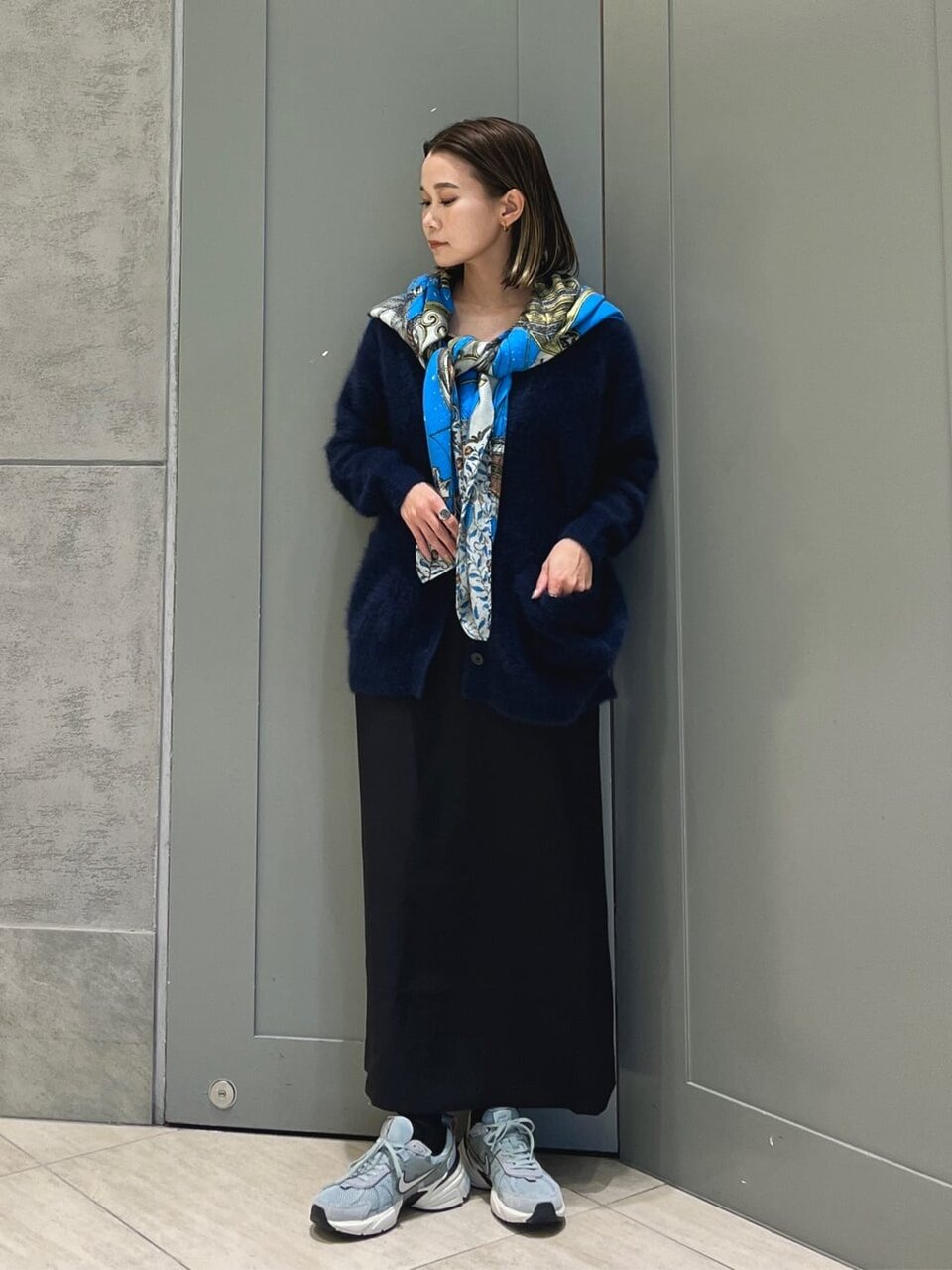 赤いニットとグレーのスカートを着た女性