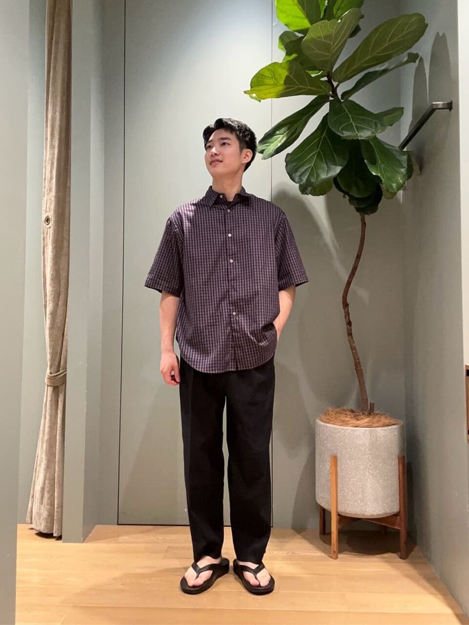 ギンガムチェック柄シャツとスラックスを着た男性