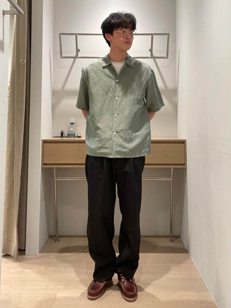 オープンカラーシャツとスラックスを着た男性