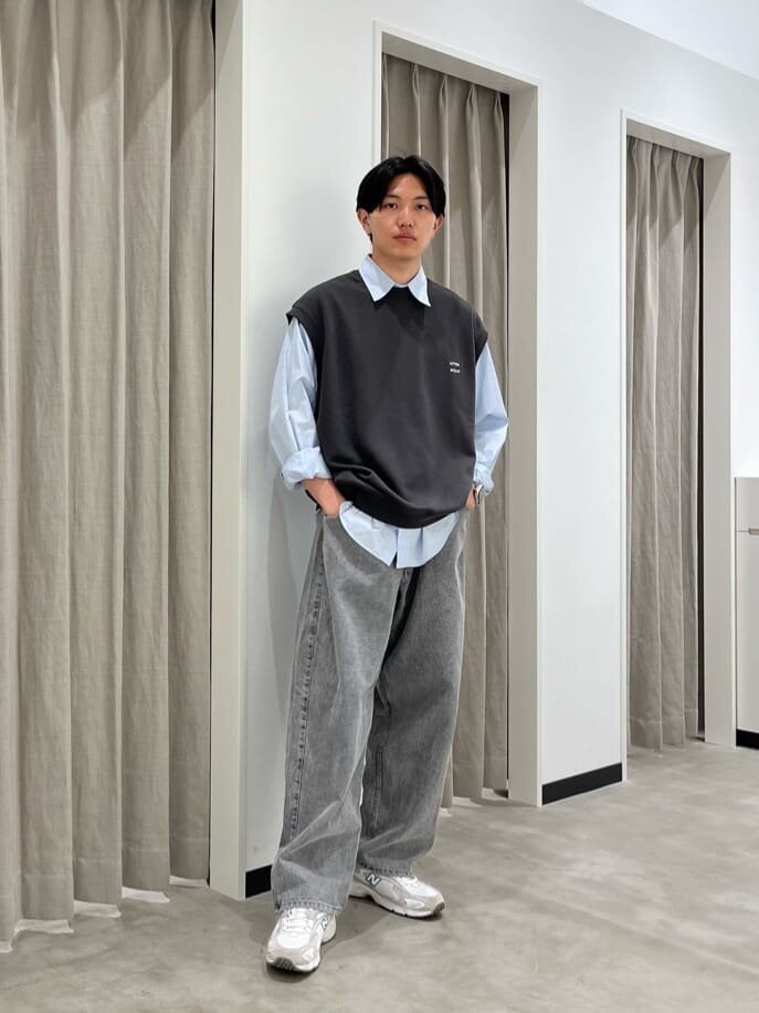 ベストとデニムパンツを着た男性