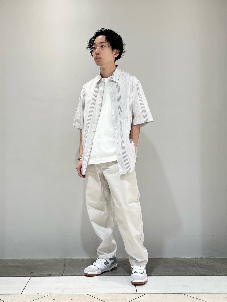 ストライプ柄シャツとイージーパンツを着た男性