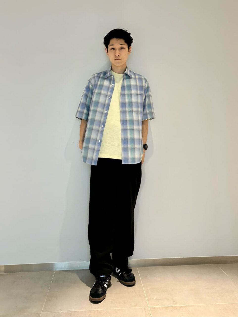 チェック柄シャツとイージーパンツを着た男性