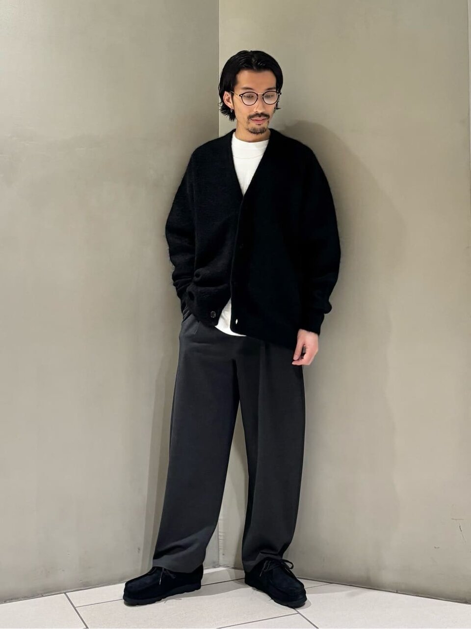 黒のカーディガンとパンツを着た男性