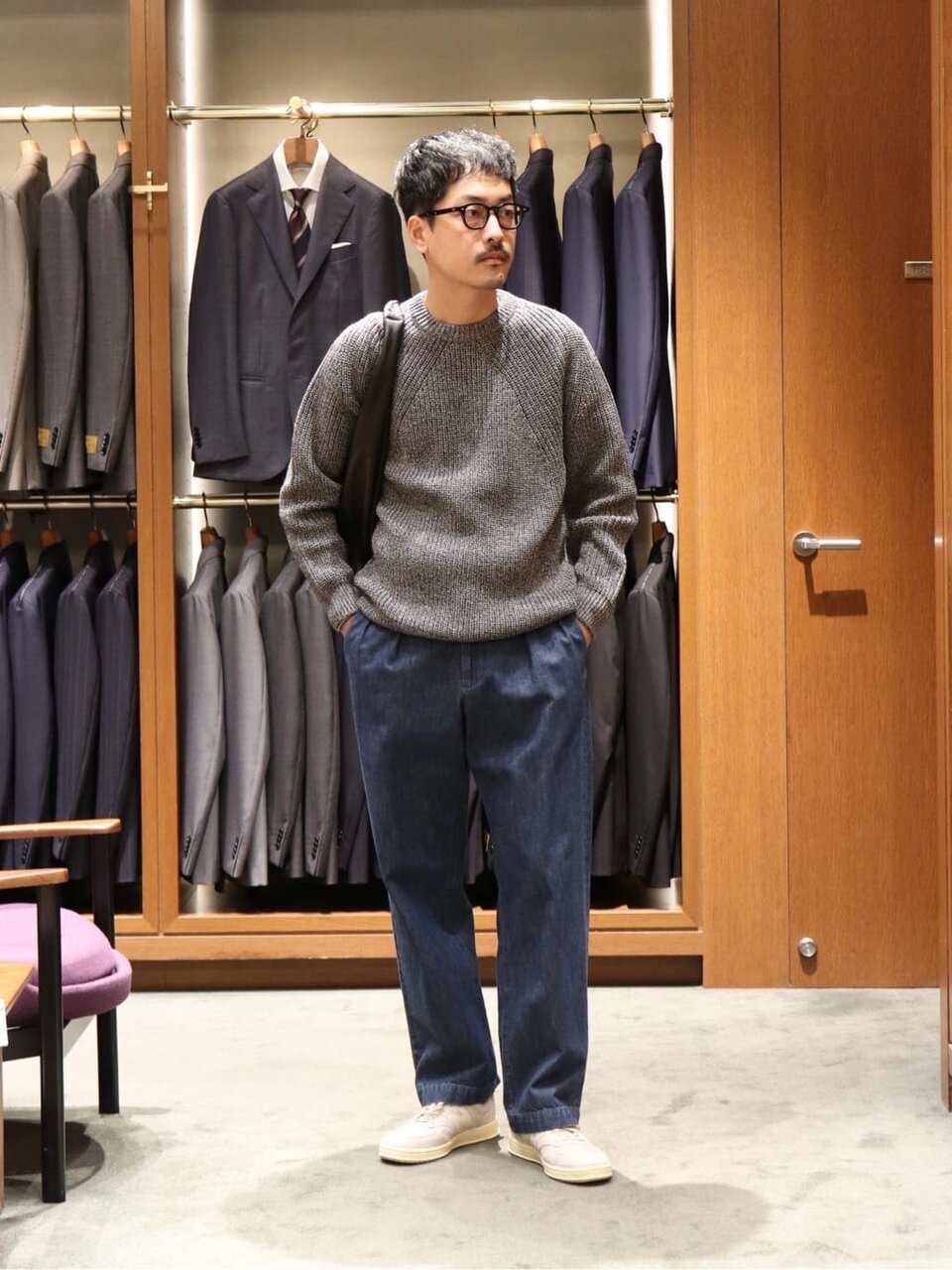 クルーネックニットとデニムを着た男性